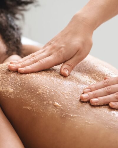 African american lady having skin scrubbing procedure at spa salon