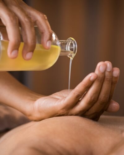 Therapist pouring massage oil at spa