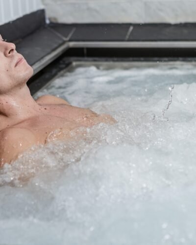 Young male relaxing in bubbling jacuzzi