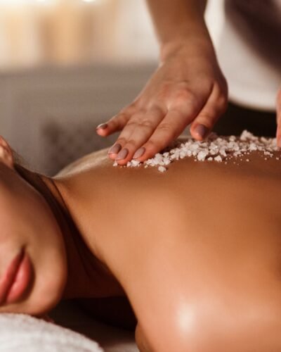 Woman enjoying salt scrub massage at spa